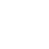 Silhouette of a modern train station or terminal building with tracks in front.