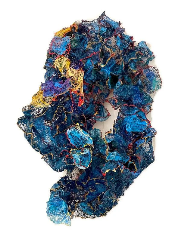 Colorful abstract textile art with blue, yellow, red, and black threads and fabric.
