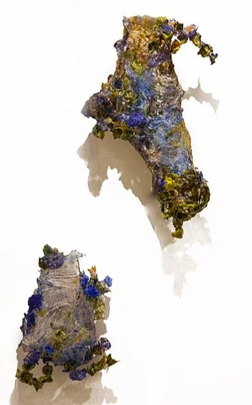 Artistic sculptures resembling the map of Italy, made with mixed materials and decorated with purple and yellow elements.