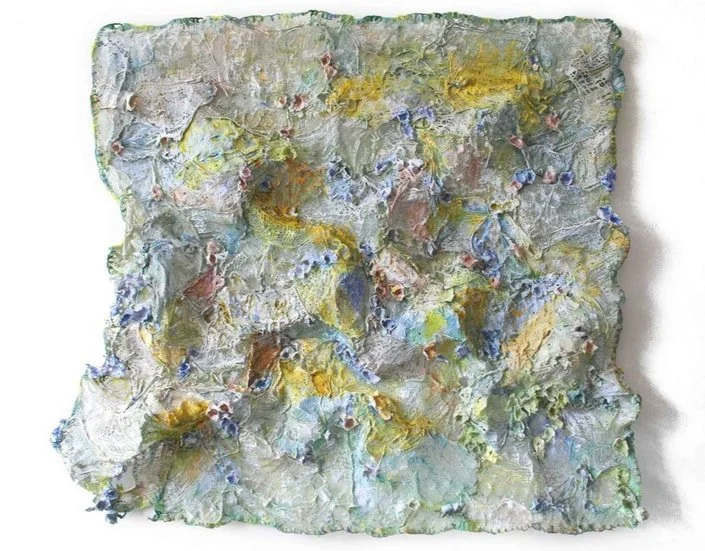 Abstract textured artwork with thick layers of pastel colors, including yellow, blue, green, and hints of red and purple, resembling an impasto painting.