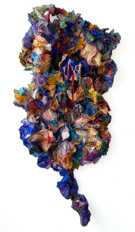 Colorful, textured fabric sculpture resembling the map of South America.