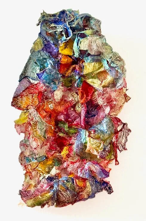 Abstract artwork created with colorful, crumpled and layered paper or fabric pieces arranged vertically.
