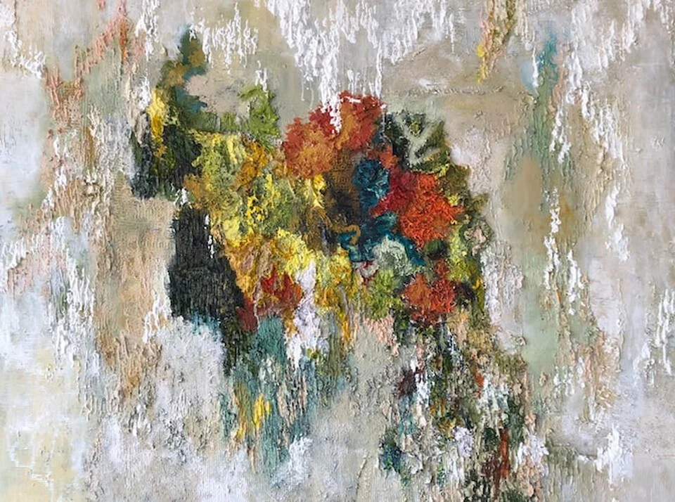 Abstract textured wall art with vibrant colors including yellow, green, red, blue, and black on a plastered wall.