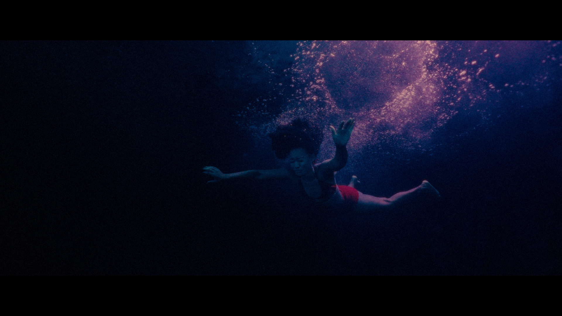 Elle in the underwater moment bathed in deep blues and purples from Betta Fish