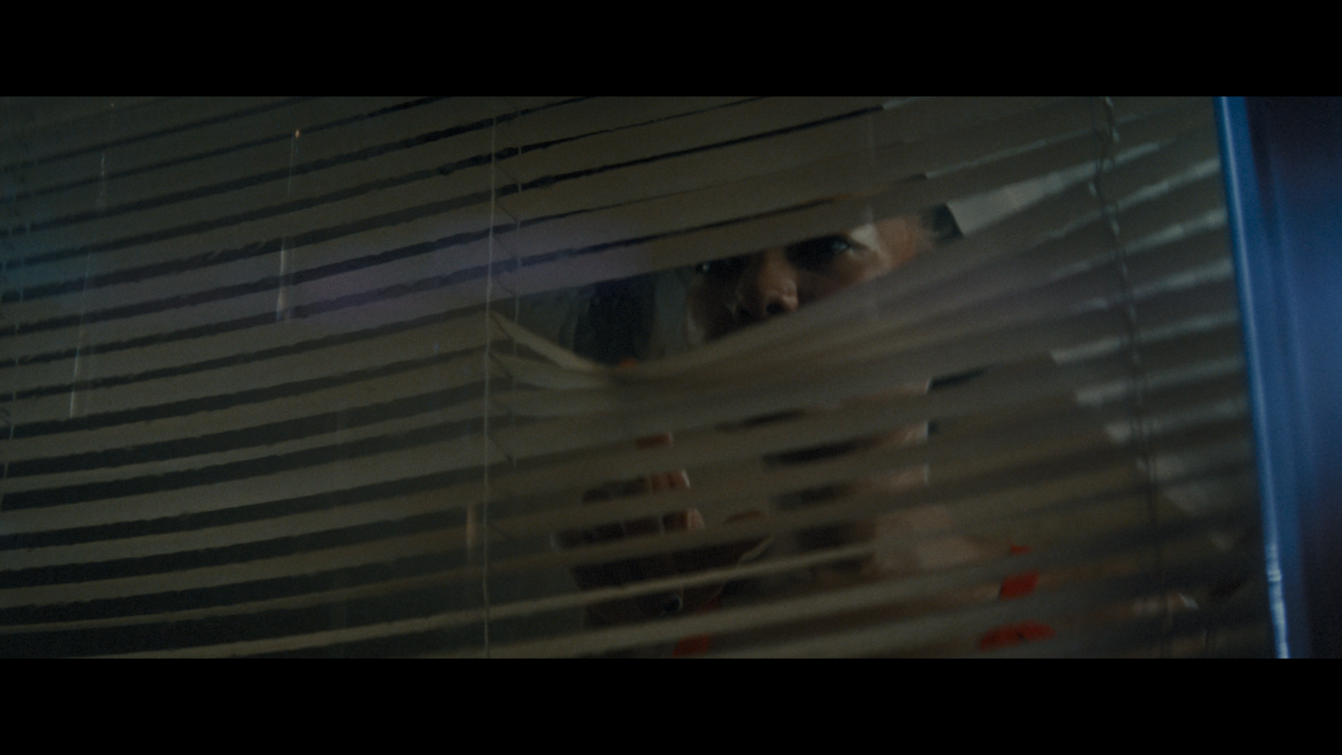 Elle looking out of the blinds in Betta Fish short film