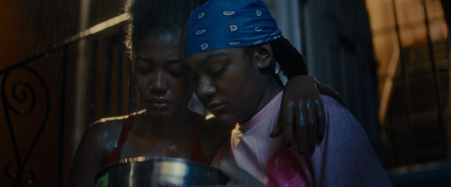 Elle and Cassidy embrace on a front stoop in an emotional scene from Betta Fish