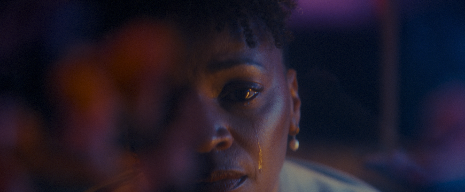 Close-up of Annette with a tear on her face in a cinematic scene from Betta Fish