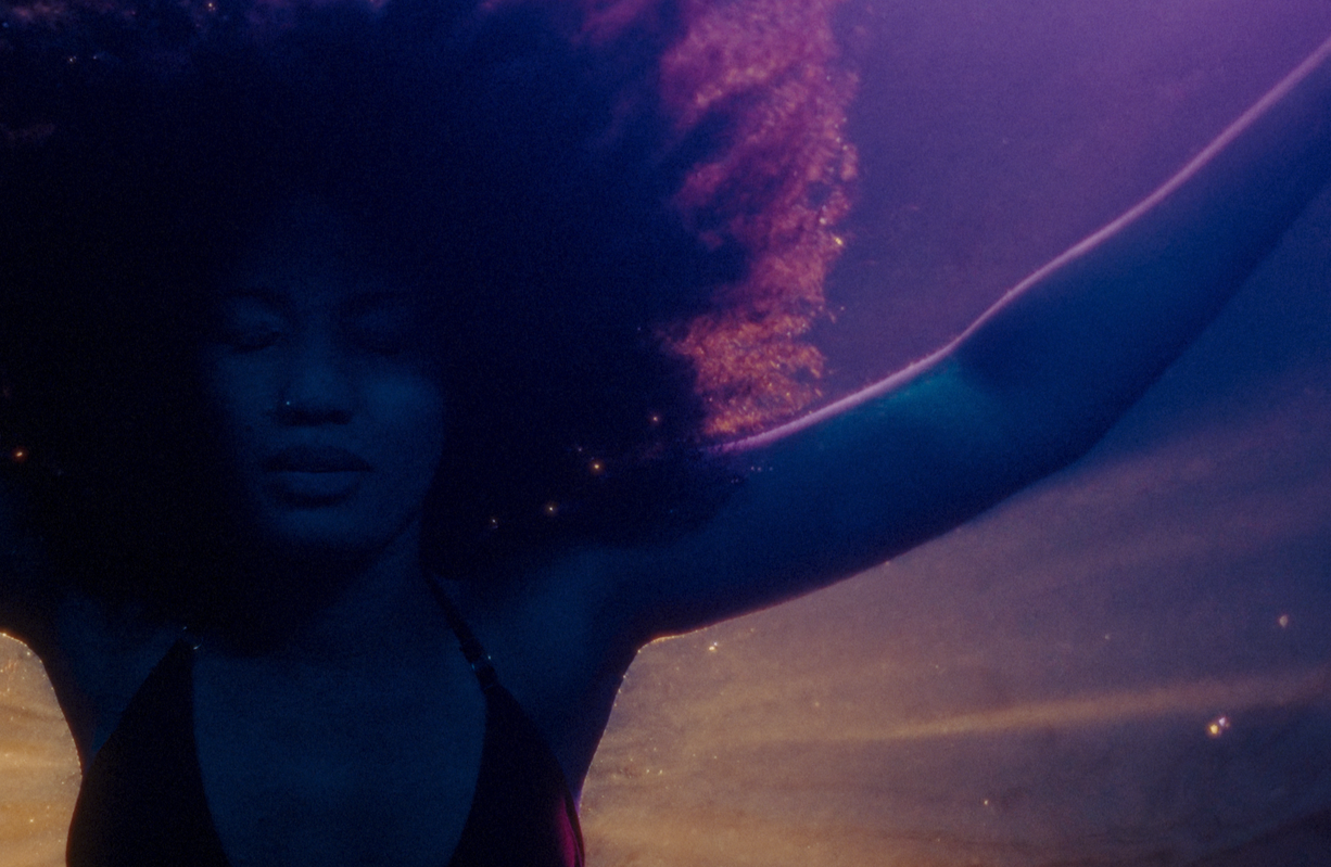 Elle floating underwater in the short film Betta Fish