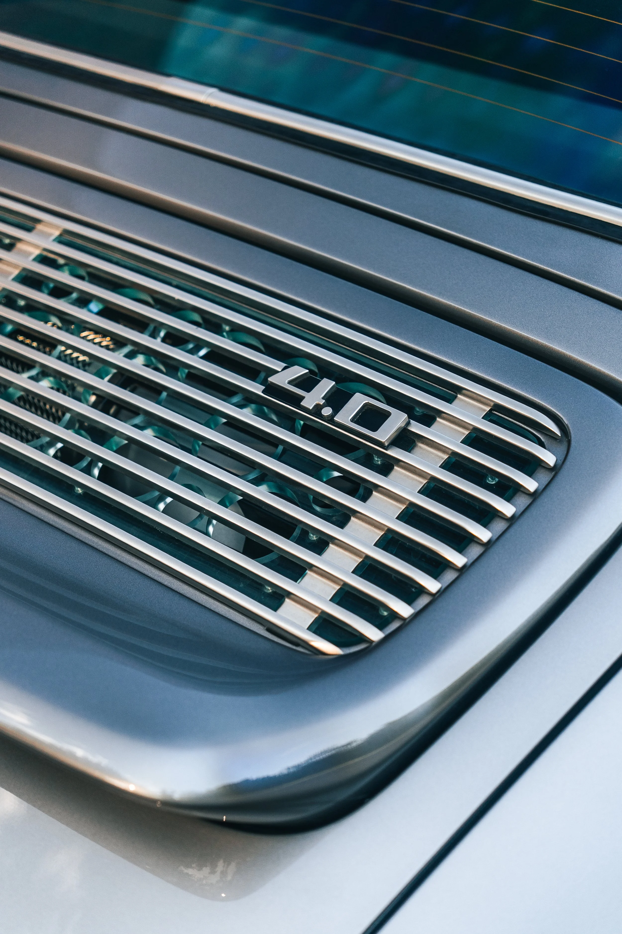 Close-up of a Singer Porsche 911 rear air vent with the badge '4.0' visible, indicating the engine size.