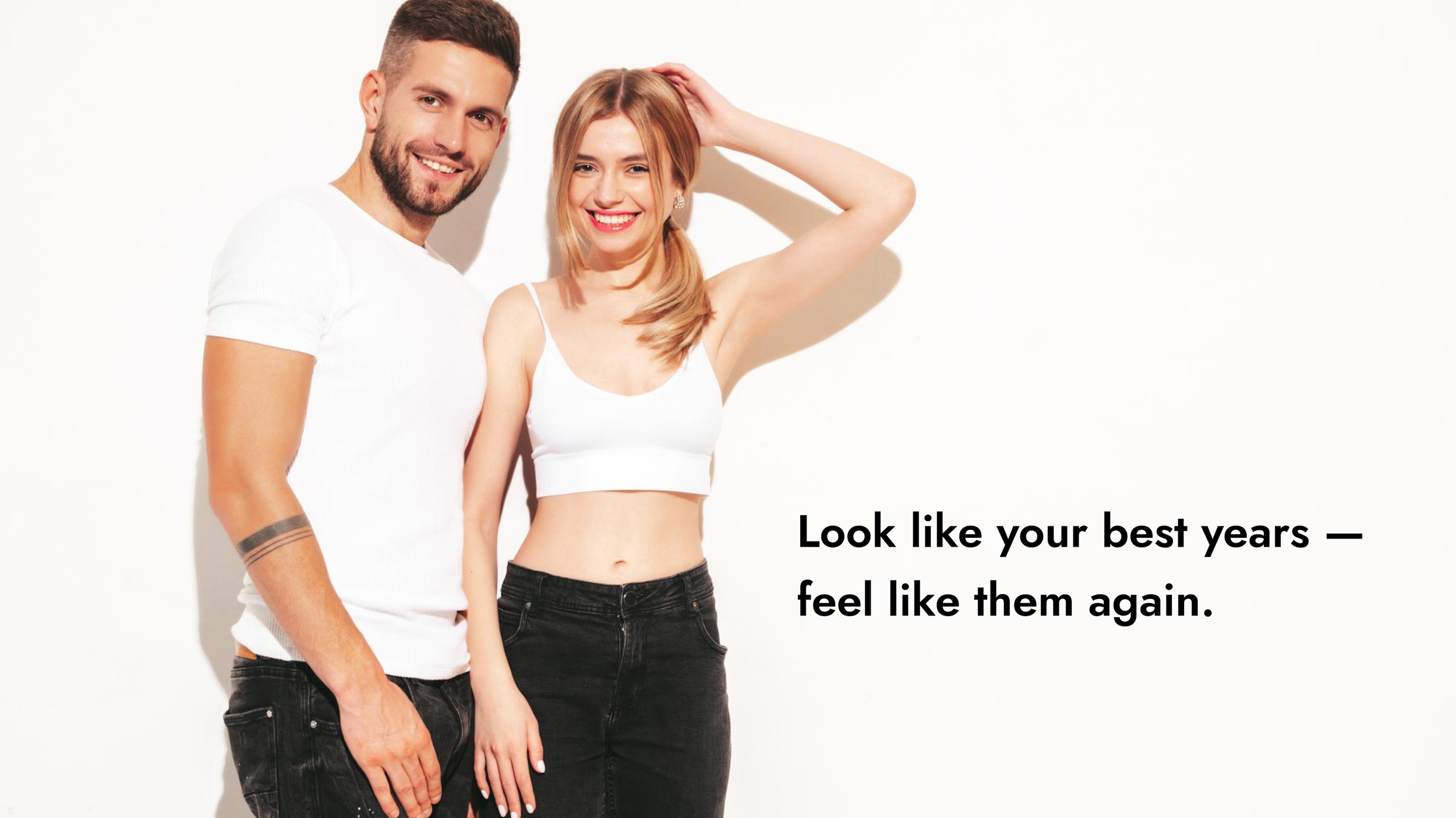 A smiling man and woman standing close together against a white background, dressed in casual white tops and black pants, with the woman touching her hair. Below them, black text reads: "Look like your best years — feel like them again."