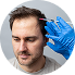 Man with a worried expression holding his head with one hand