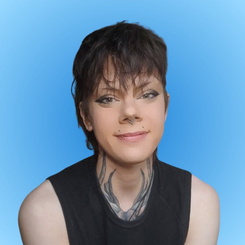 Portrait of a woman with short black hair, tattoos on her neck, and piercings on her face, wearing a sleeveless black top, smiling against a blue gradient background.