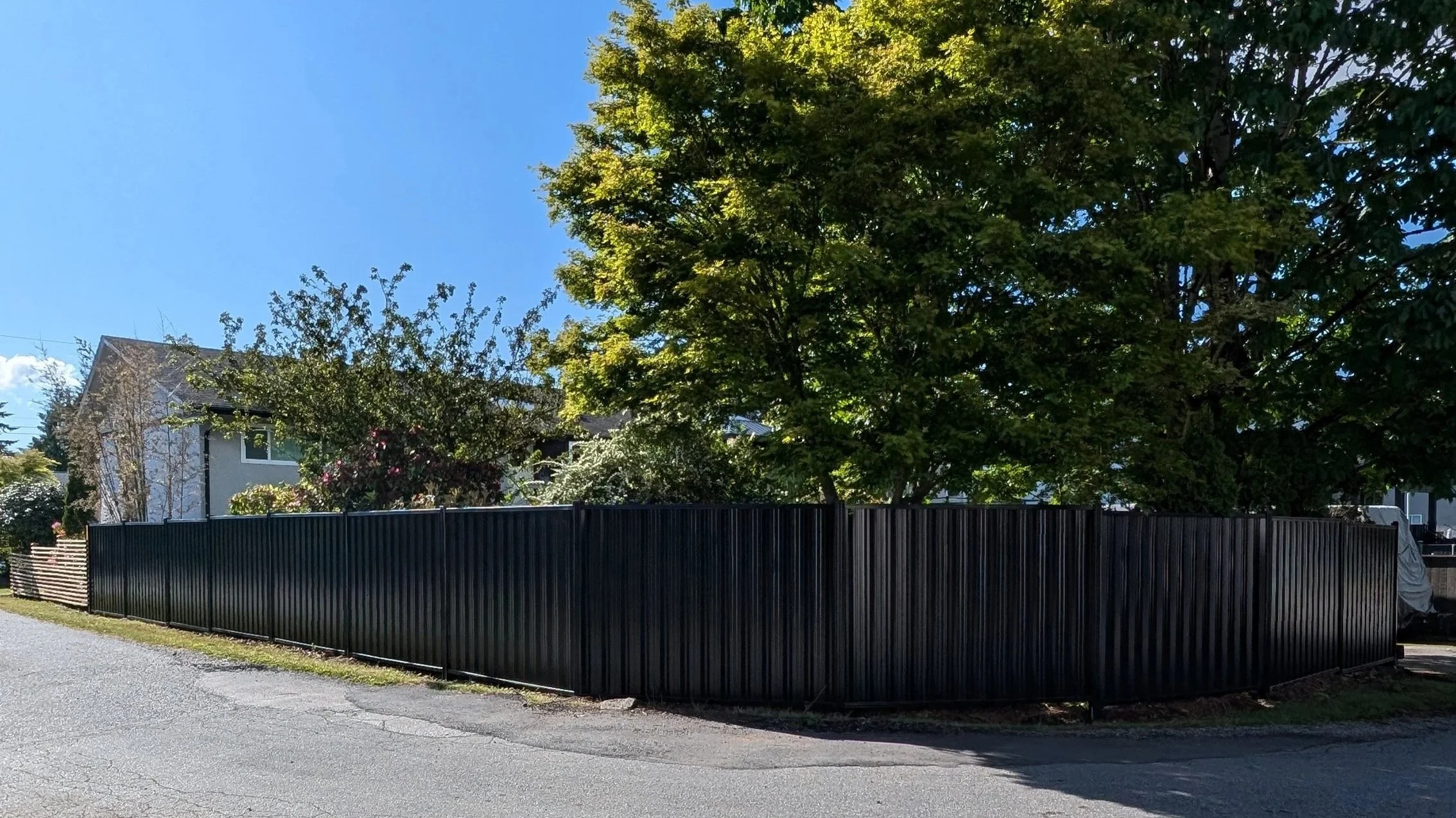 Modern black, metal fence along a residential street - Coquitlam