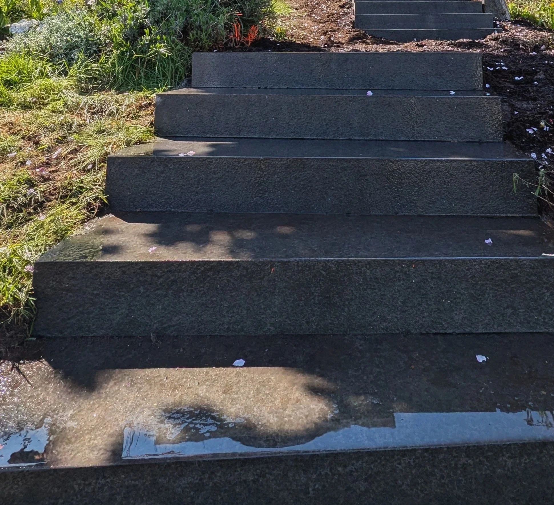 Flamed granite outdoor steps built into a sloped garden - Burnaby