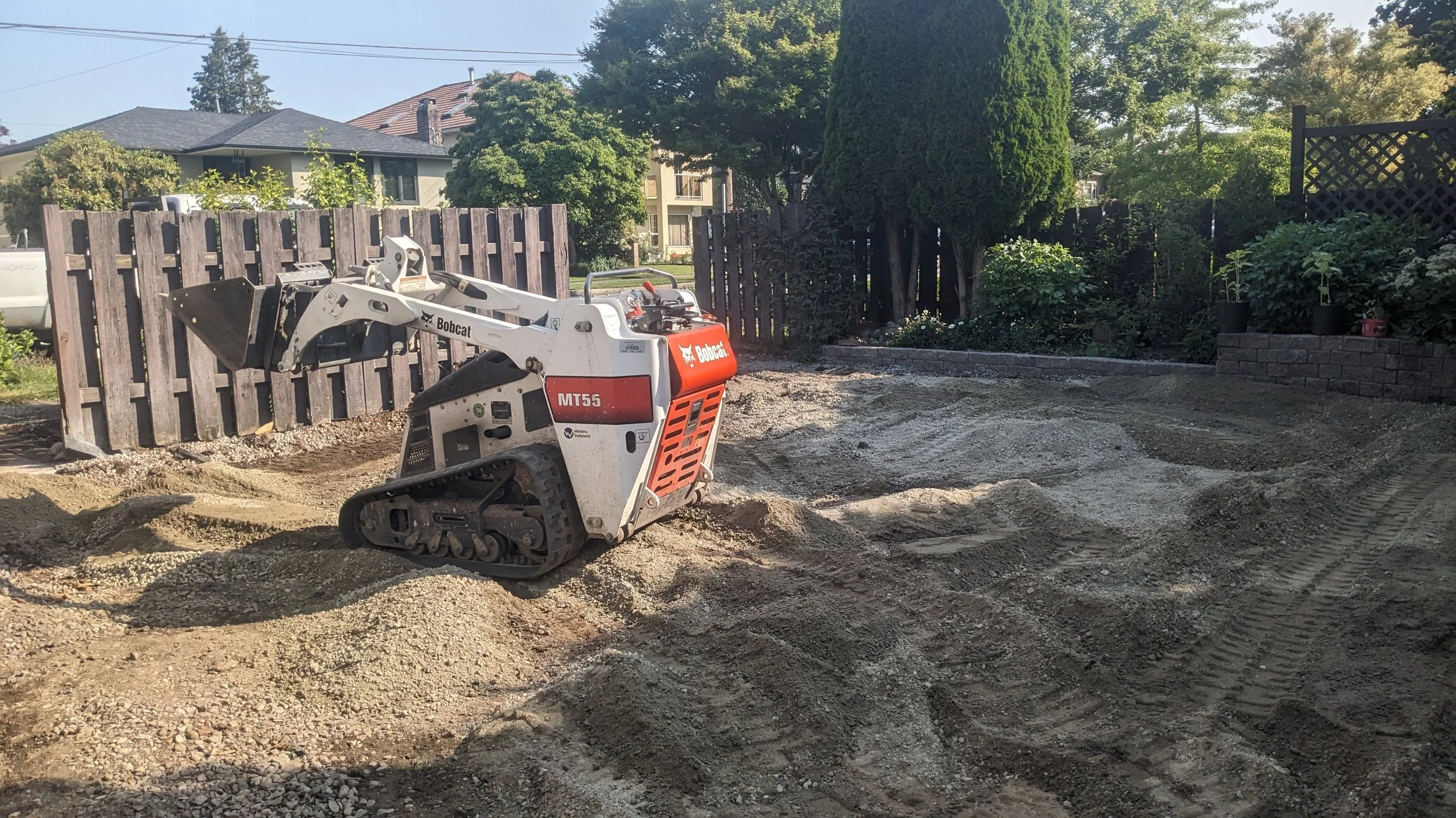 Bobcat mini skid steer grading base for a backyard hardscape project - New Westminster