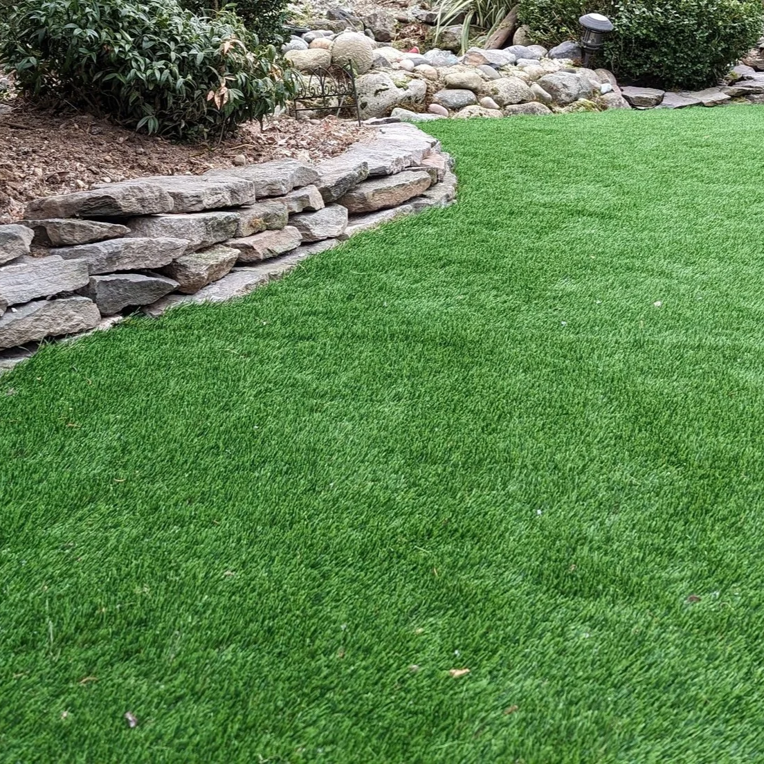 Artificial turf with a natural stone, basalt wall - Burnaby backyard