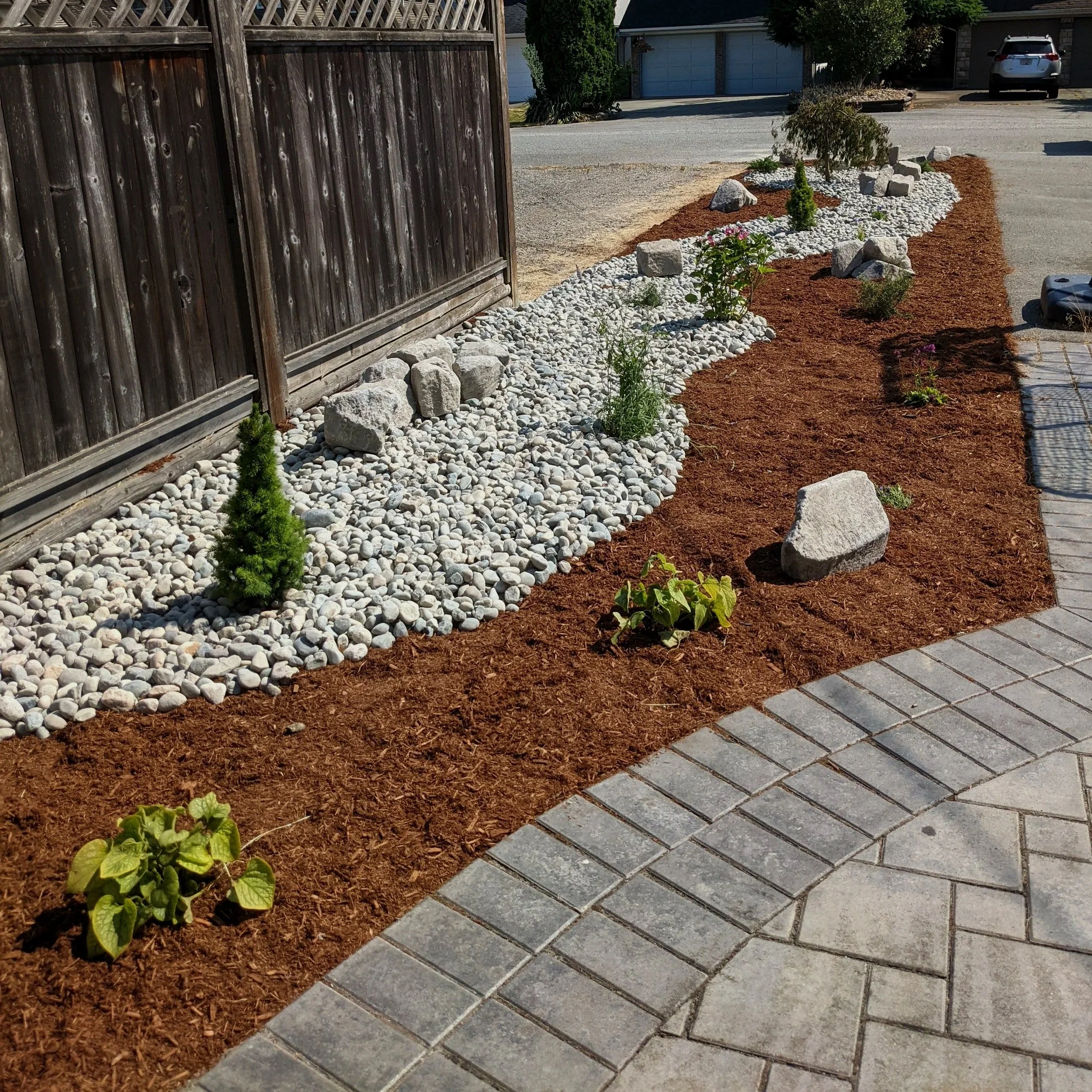 River rock and mulch garden with new herb and shrub plantings - Burnaby backyard