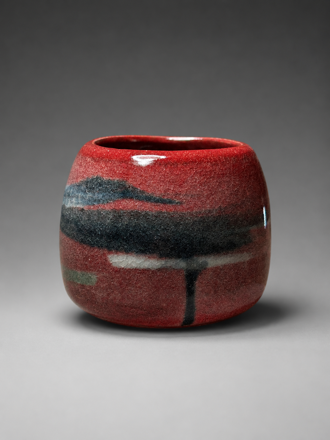 Glossy red ceramic vessel still-life.png