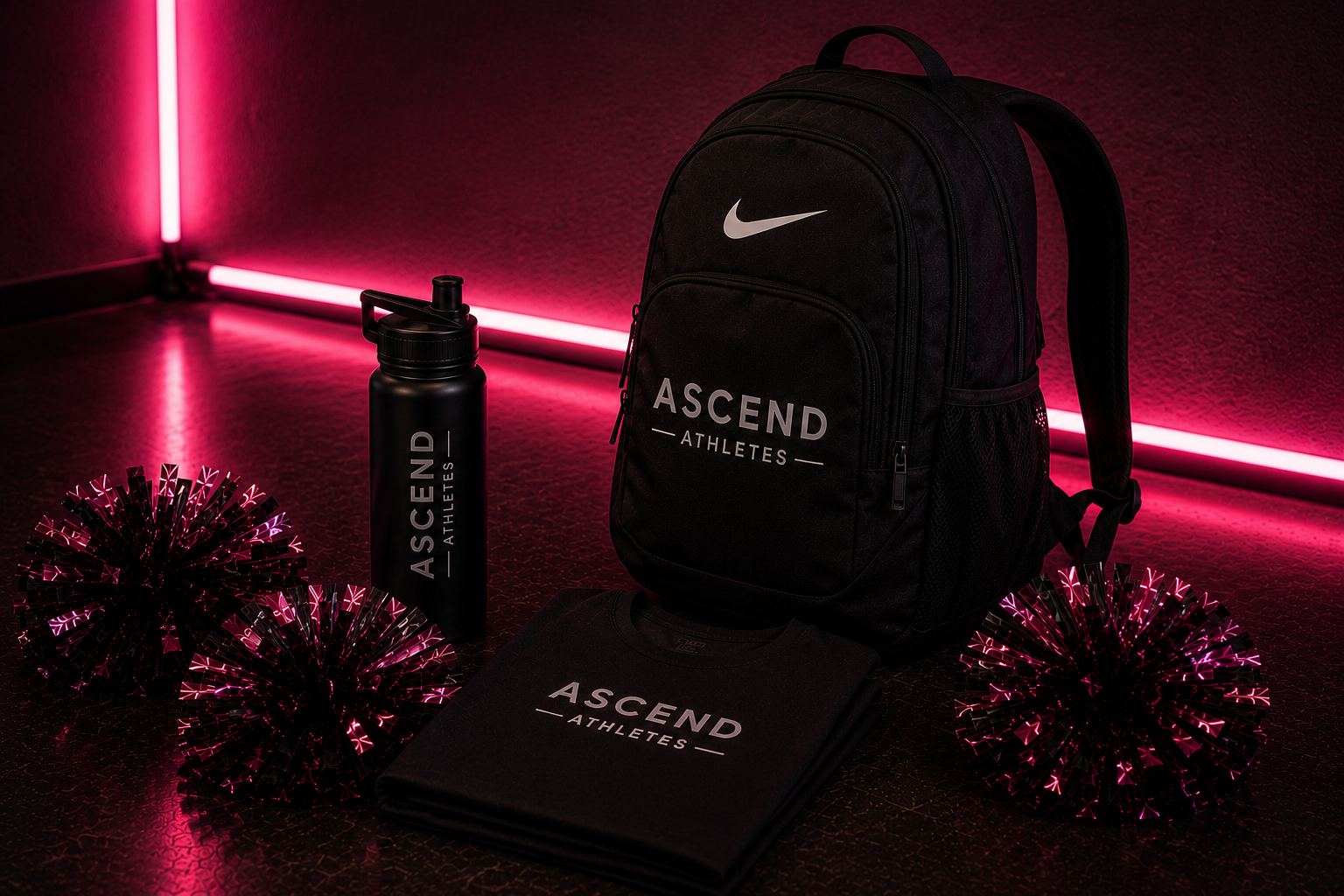 A black Nike backpack, a black water bottle, a folded black shirt, and three pink pom-poms with black and pink reflective details, all branded with 'ASCEND ATHLETES,' arranged on a dark textured floor with pink neon lighting in the background.