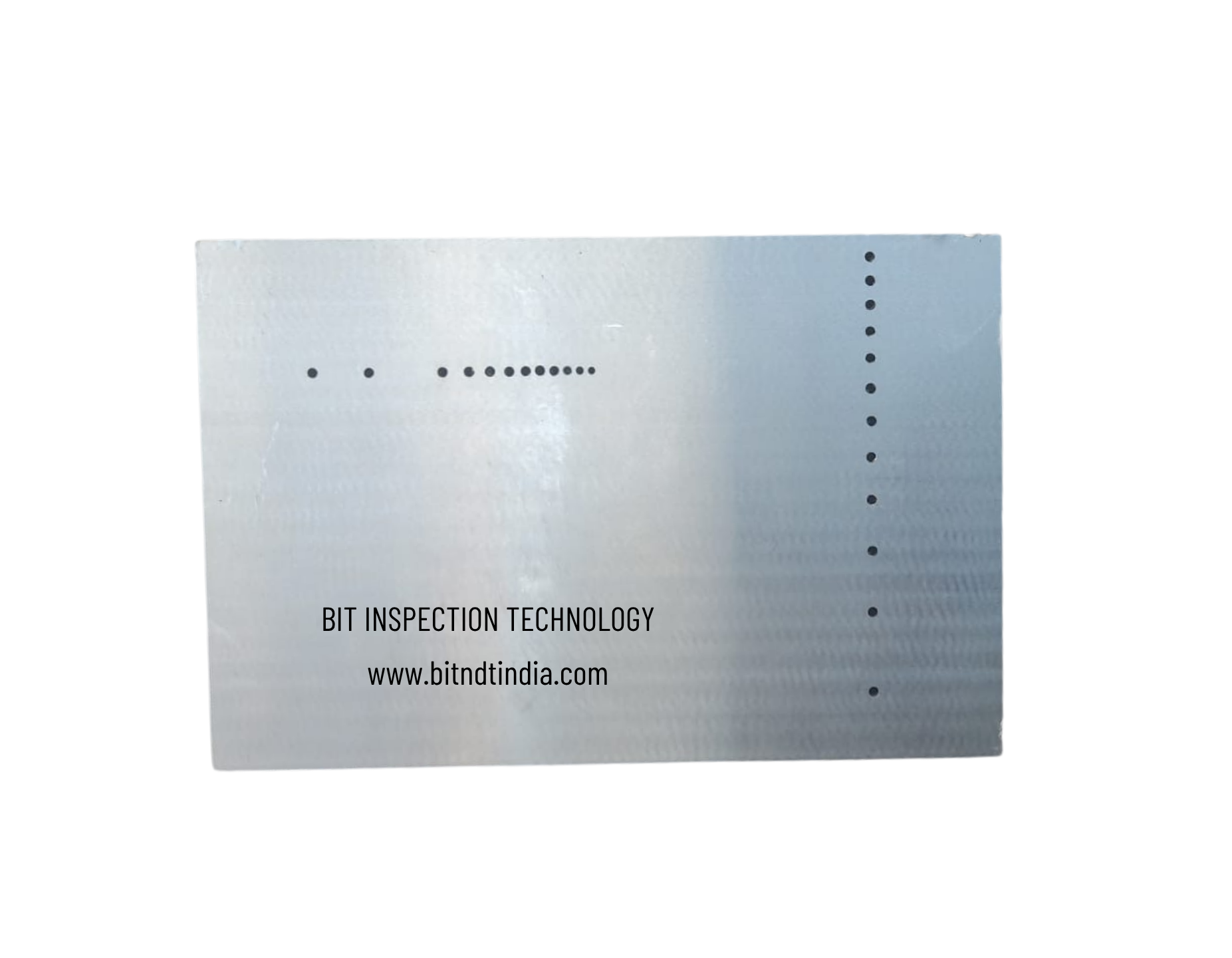 Close-up of a printed label with text 'BIT INSPECTION TECHNOLOGY' and website 'www.bitlndindia.com' on a metallic surface.