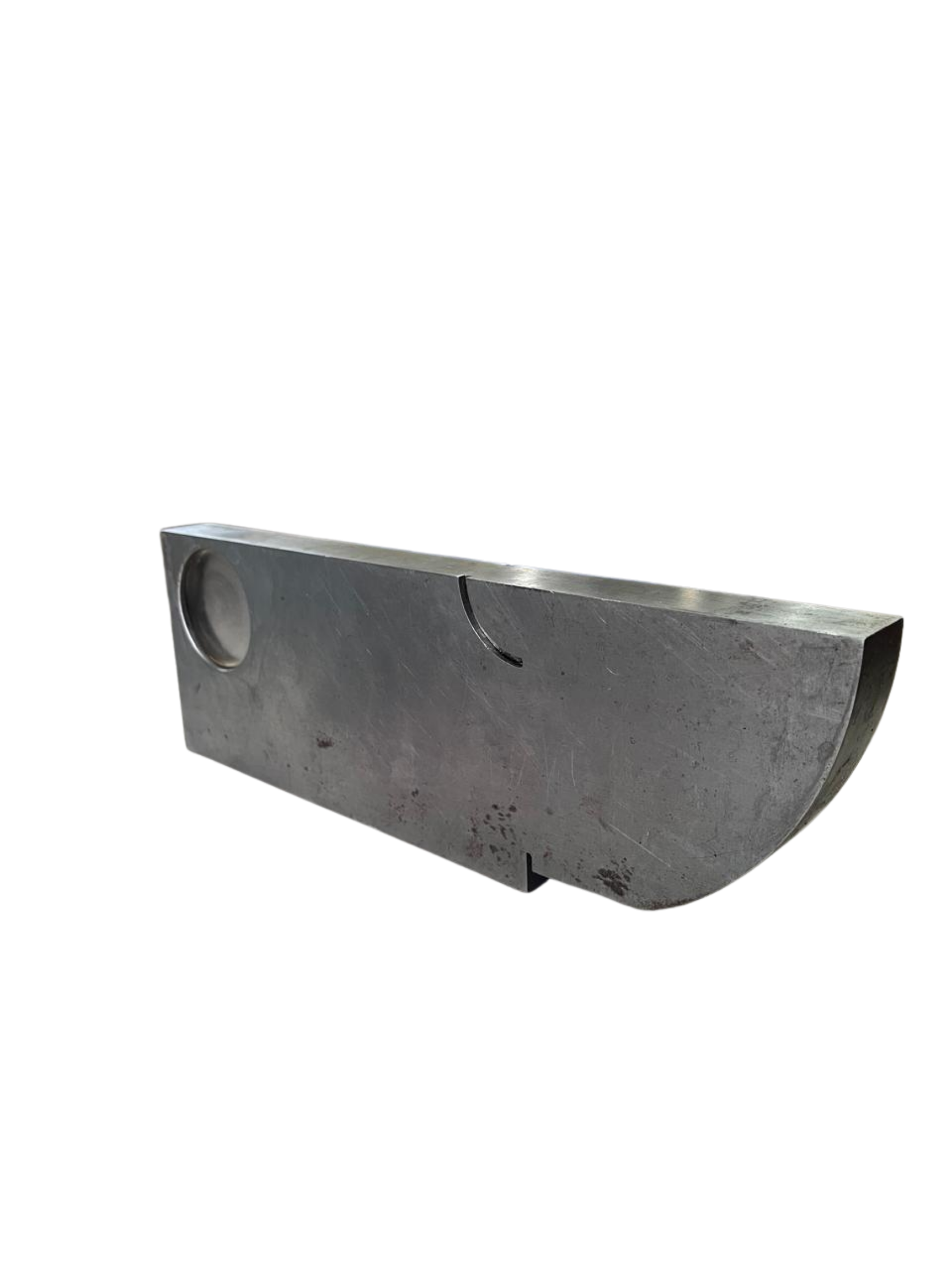 A large, rectangular metal piece with a circular indentation on one end and a curved section on the opposite end, showing signs of wear and scratches.