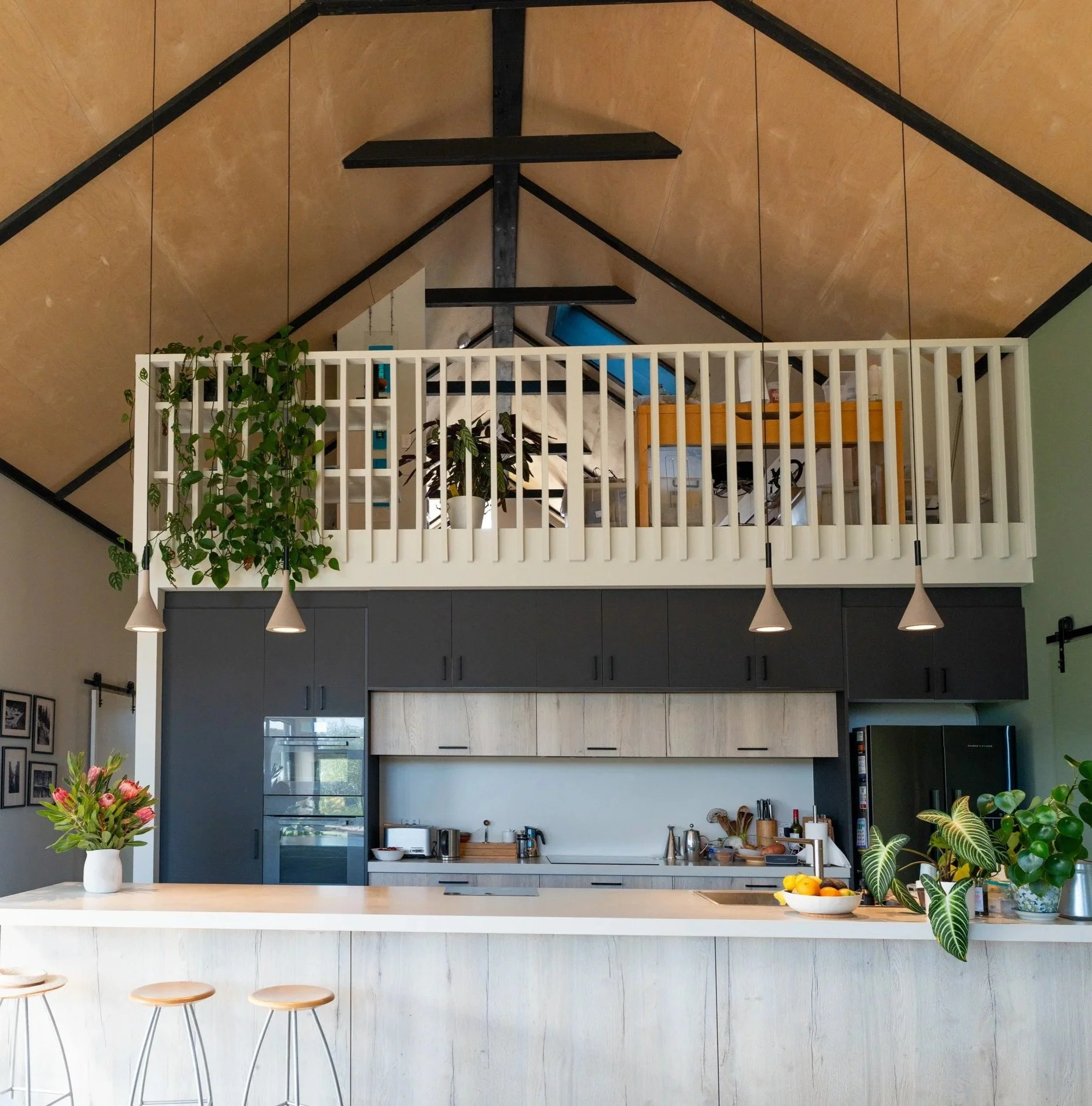 Kitchen and mezzanine inside sustainable barn-style house at Witchcliffe Ecovillage