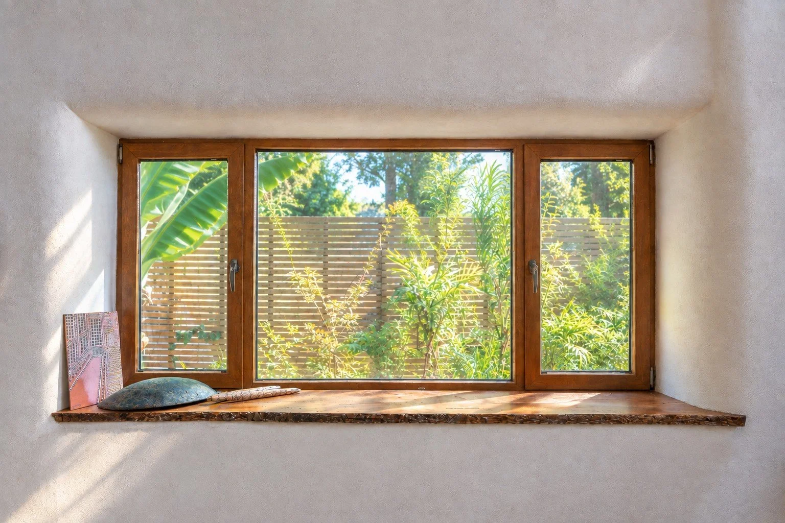 Built-in timber window seat in sustainable straw bale house at Witchcliffe Ecovillage overlooking the garden