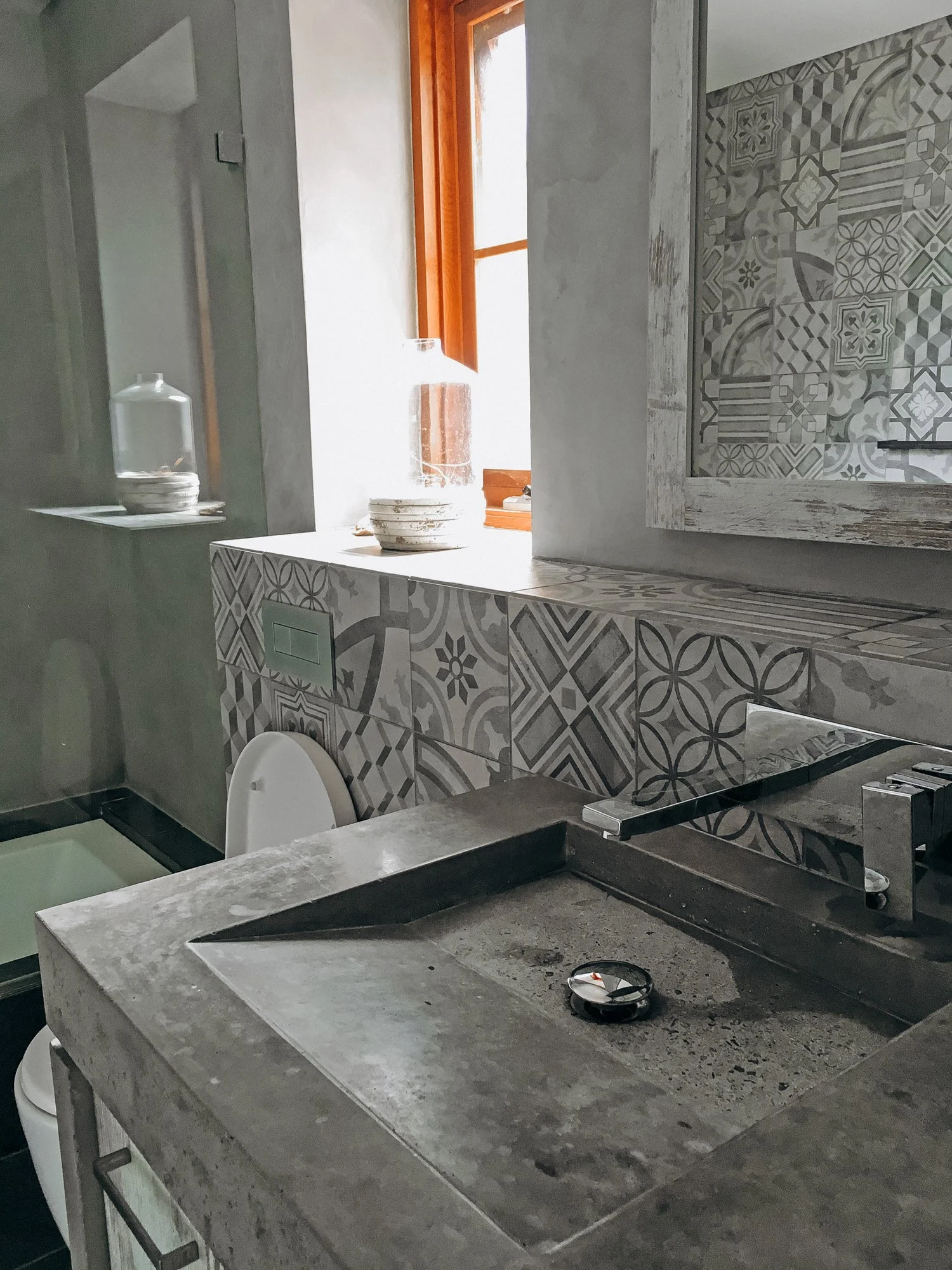Bathroom in sustainable straw bale house in Hilton with concrete basin and patterned tile finishes