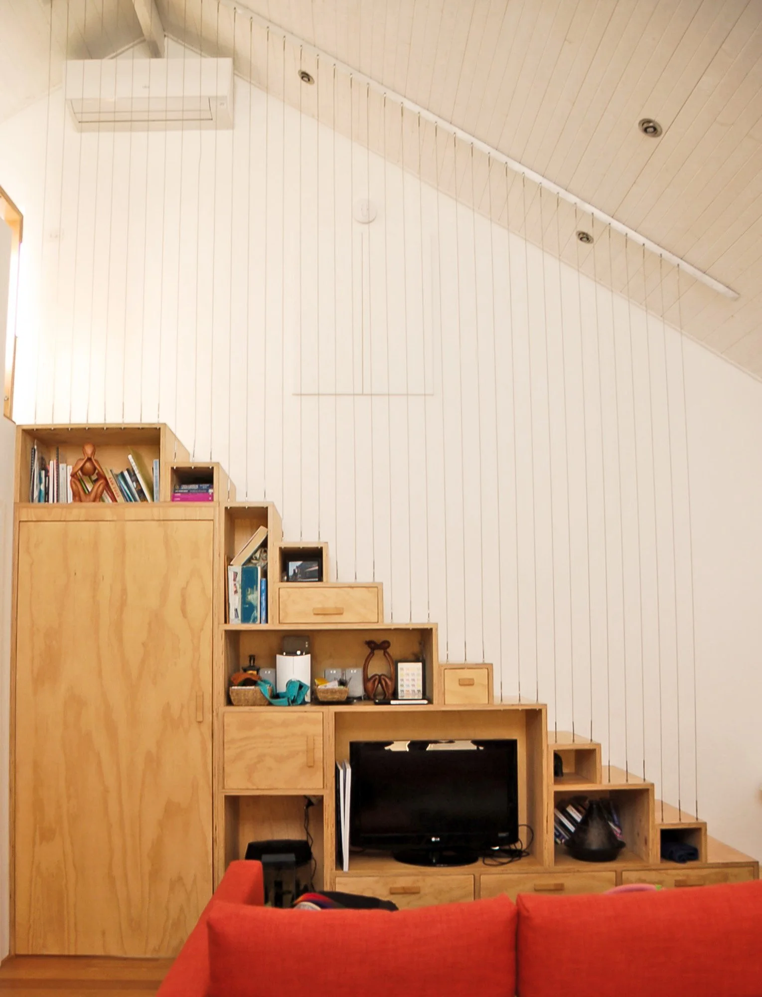 Integrated timber storage and staircase in compact straw bale house in Hilton WA