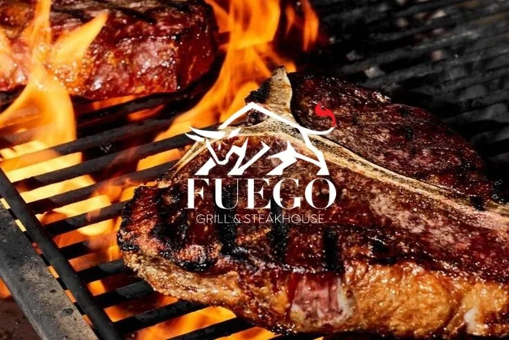 A large steak grilling on a barbecue with flames in the background and Fuego Grill & Steakhouse logo overlaid.