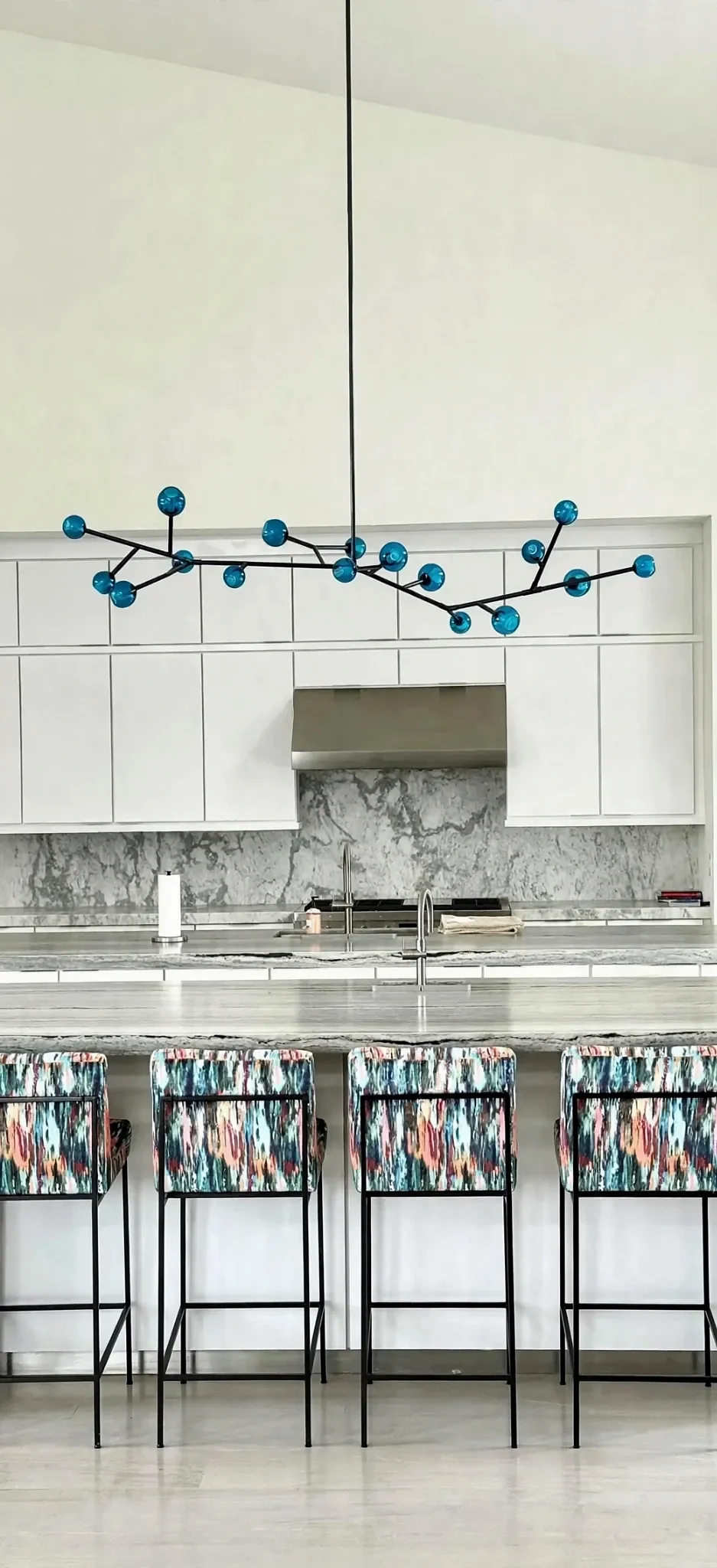 Contemporary white kitchen with blue pendant lighting at Ranch Gate