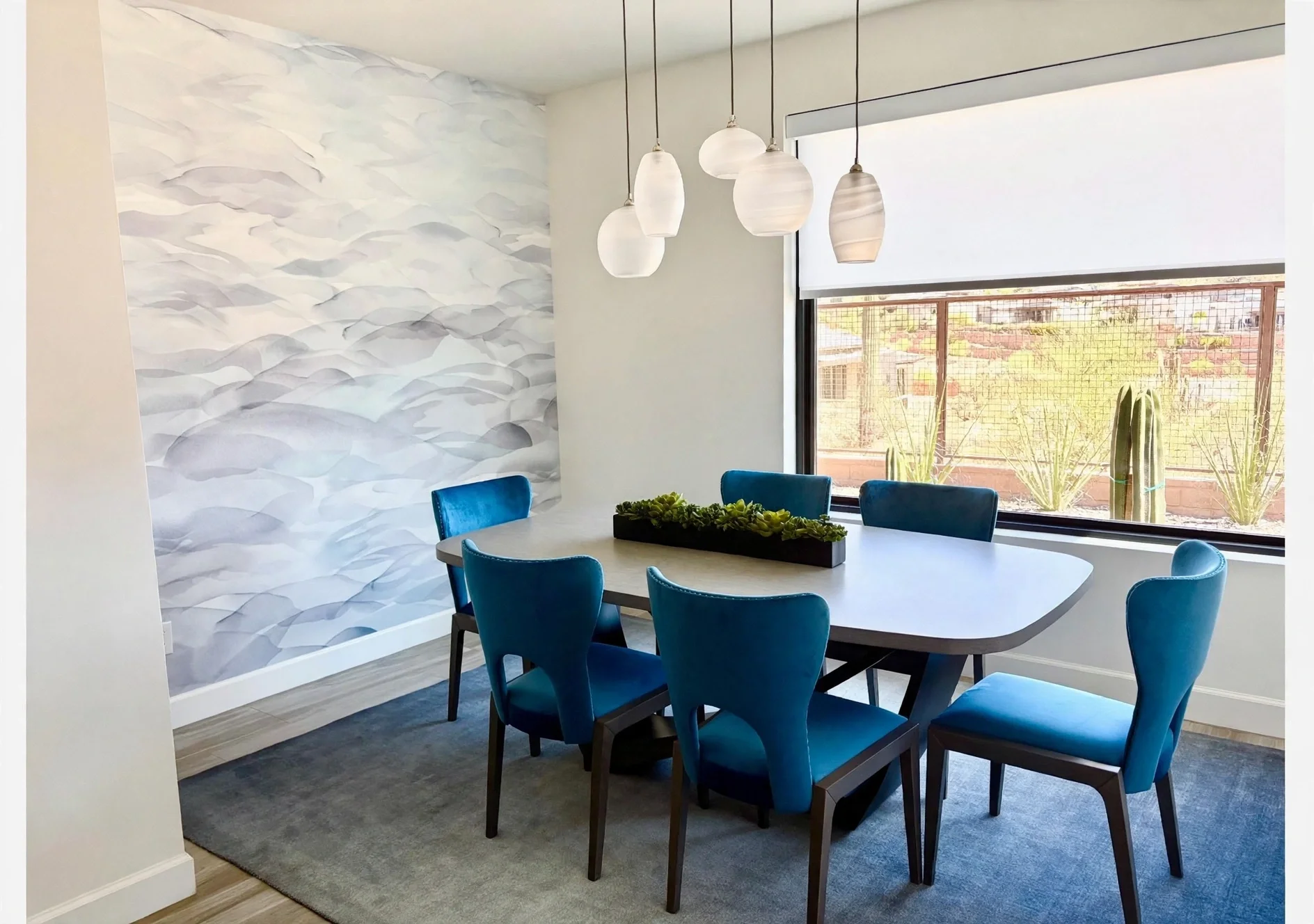 Contemporary dining room with blue velvet chairs and sculptural pendant lights at Adero Canyon in Fountain Hills