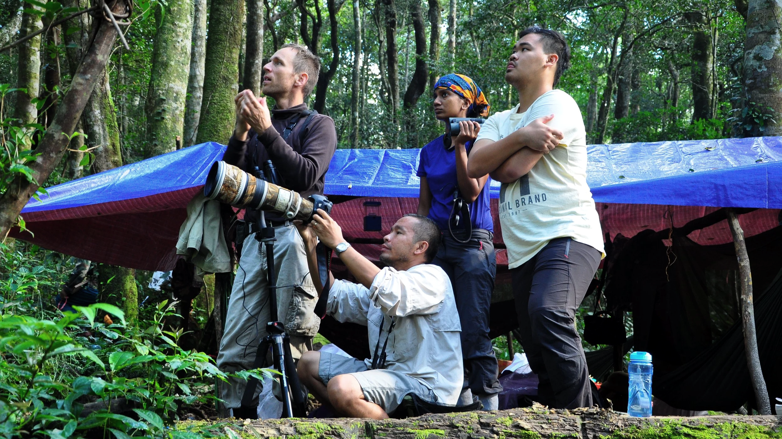 NUS scientists observing wildlife or scenery, with camera equipment and a makeshift shelter in Nui GIang Man, Vietnam