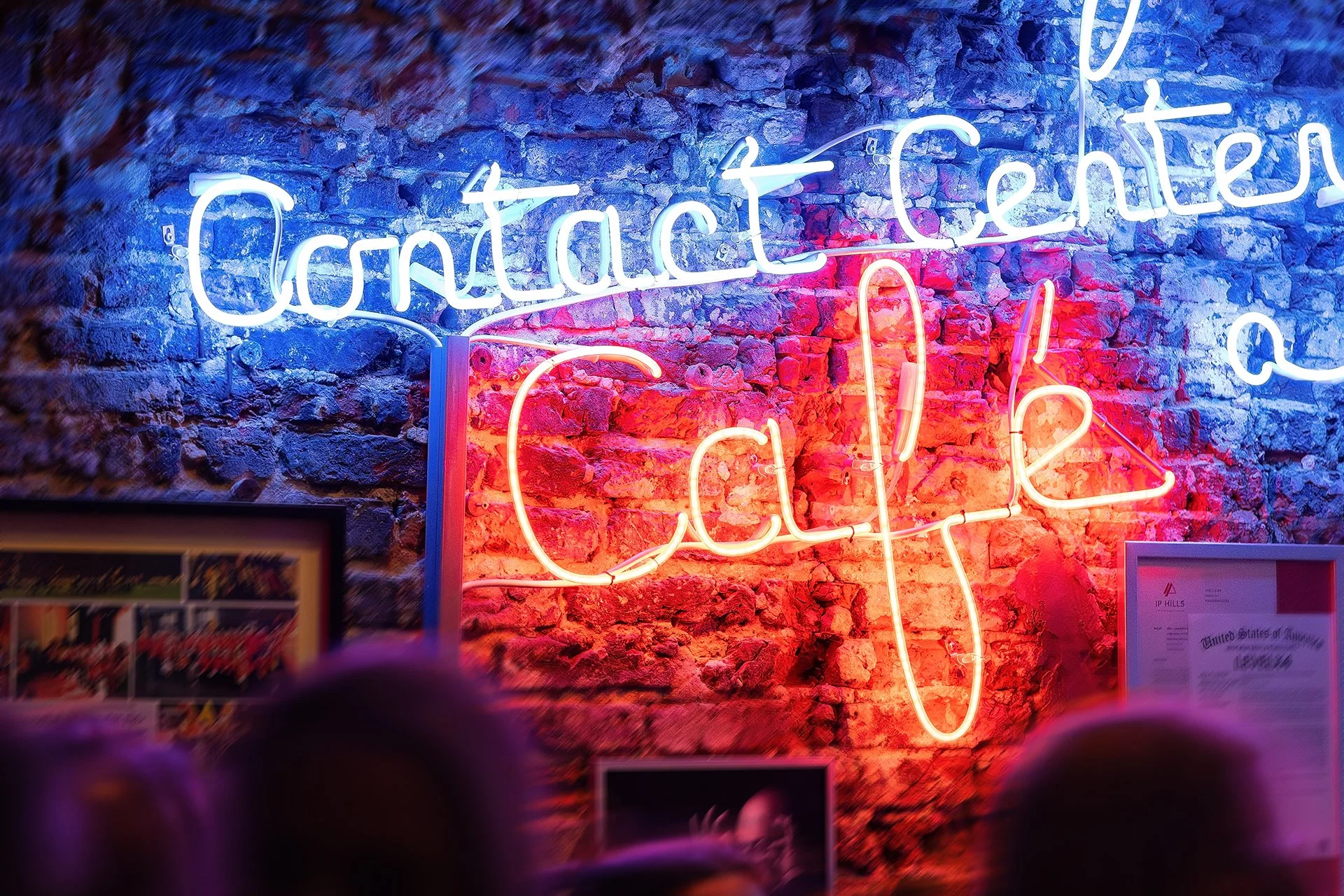 Neon sign on a brick wall reading 'Contact Center' with a guitar shape in red neon lights below.