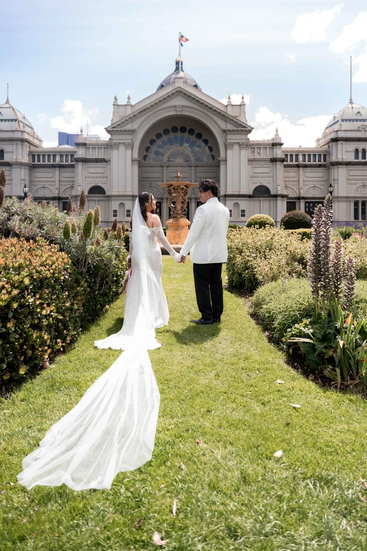 Bride and groom holding hands outside a historic Melbourne wedding venue.