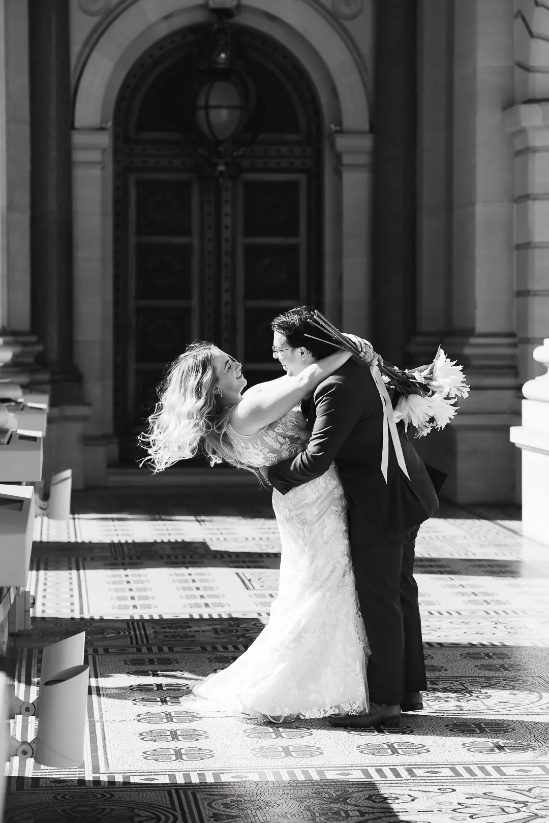Bride and groom laughing together during their first dance at the wedding reception.