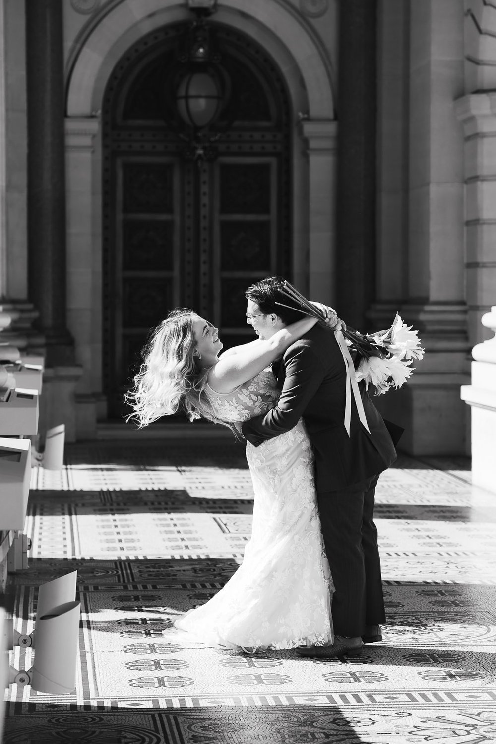 Bride and groom laughing together during their first dance at the wedding reception.