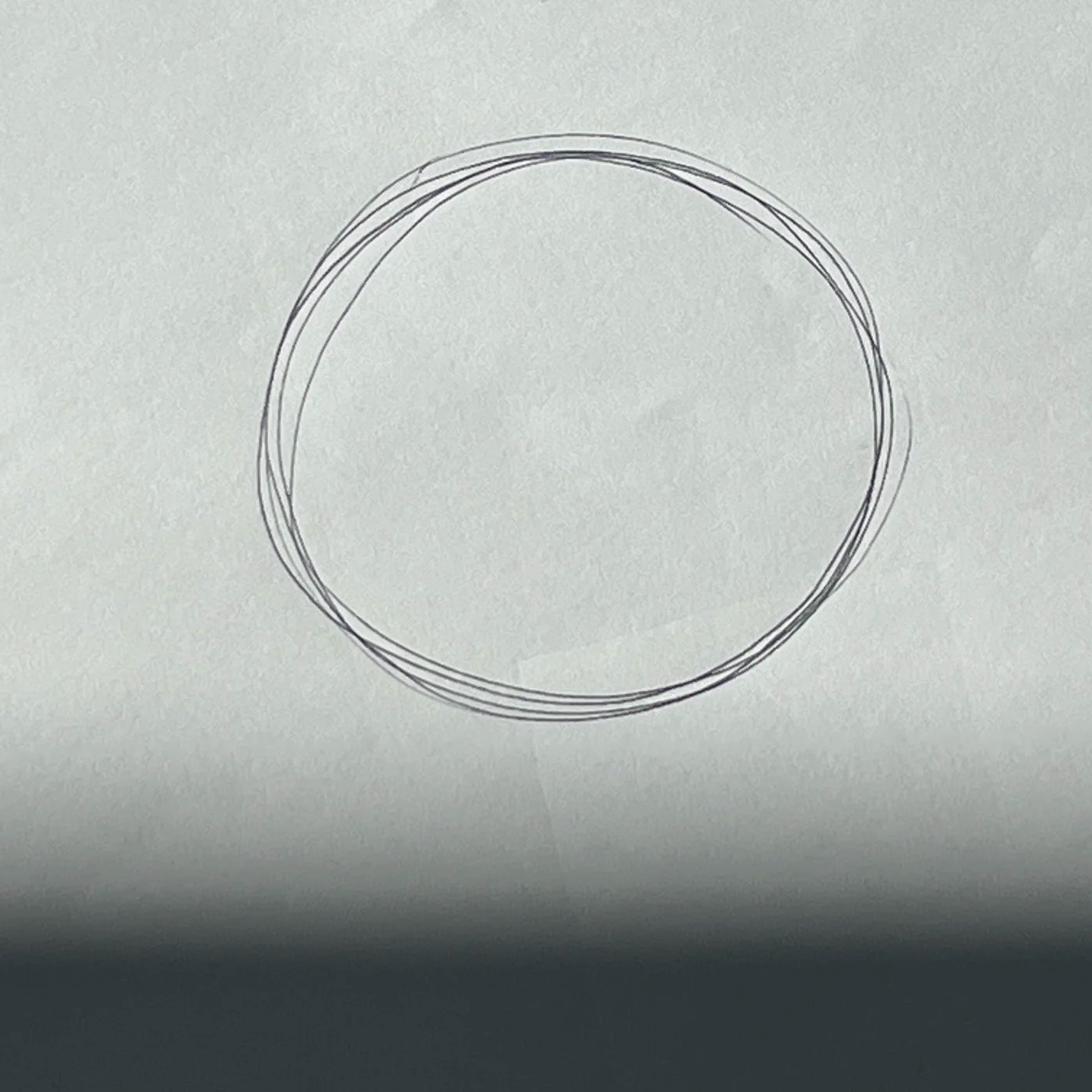 A drawing of a circle on a white sheet of paper.