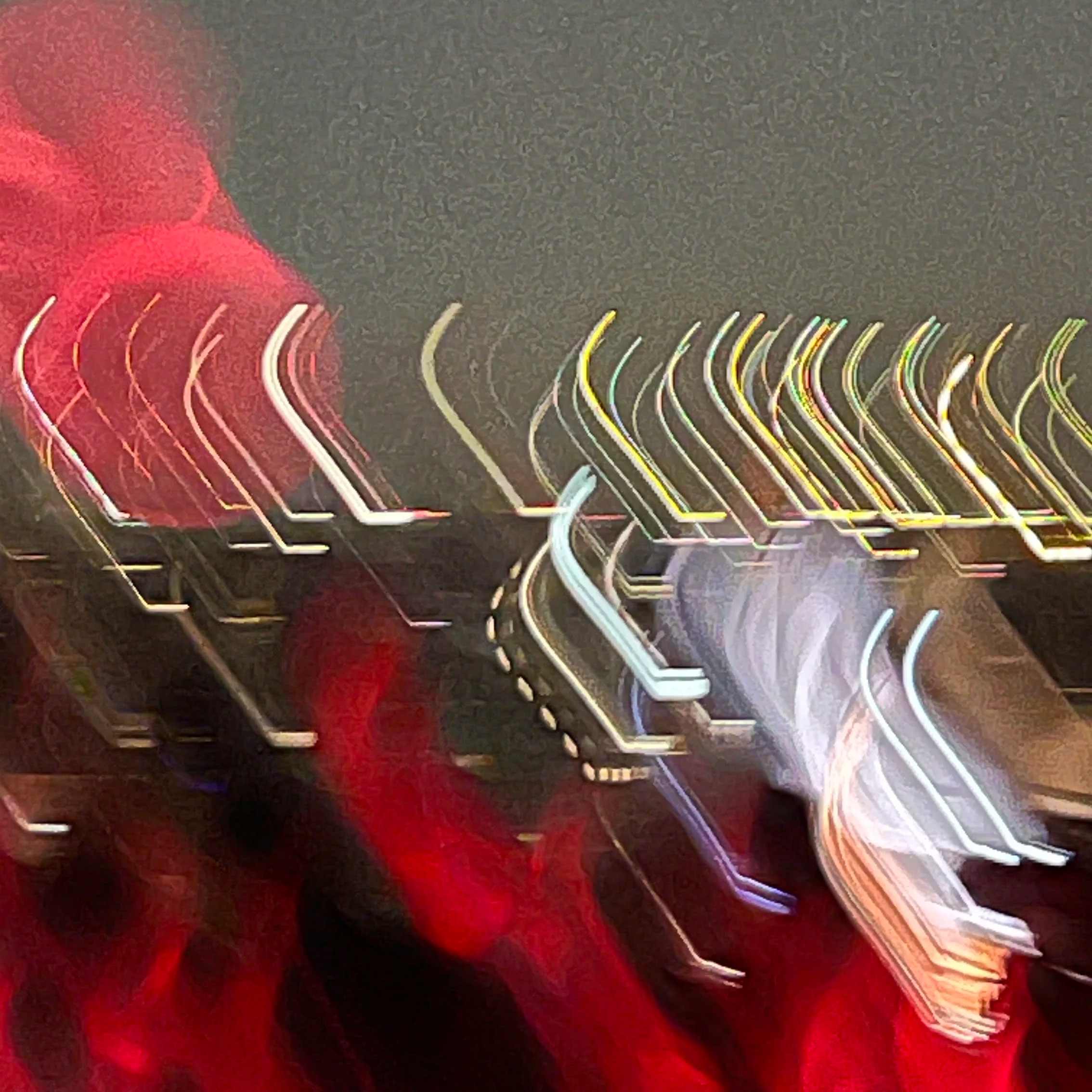 Blurred lights creating streaks of red, white, yellow, and green colors on a dark background, resembling a city street at night with moving vehicle lights.