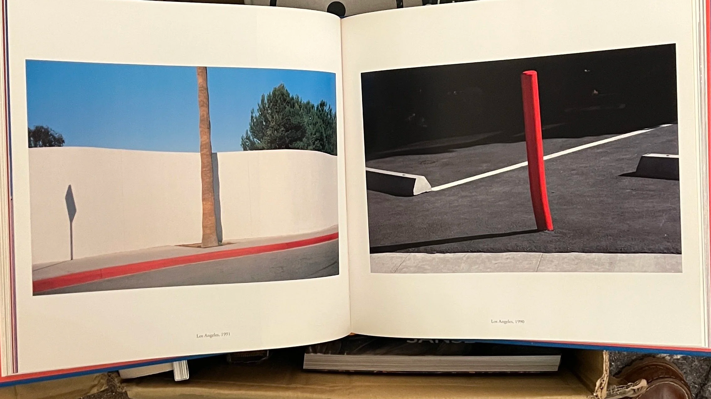 Photographs of streets in Los Angeles from 1991 and 1990, showing sidewalk curbs, a red pole, and shoes at the bottom edge.