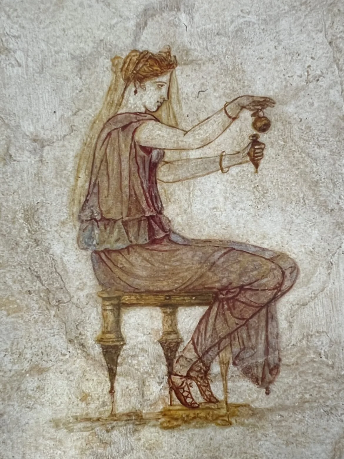 Ancient fresco of a woman sitting on a stool, holding an alabaster container and a bowl, dressed in traditional garments.