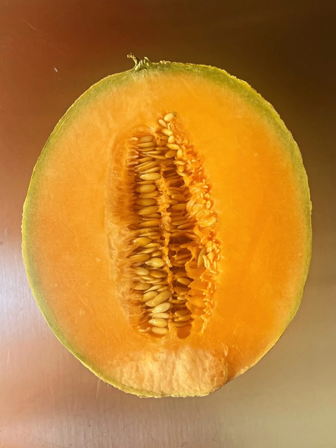 Half of a butternut squash showing bright orange flesh and seeds.