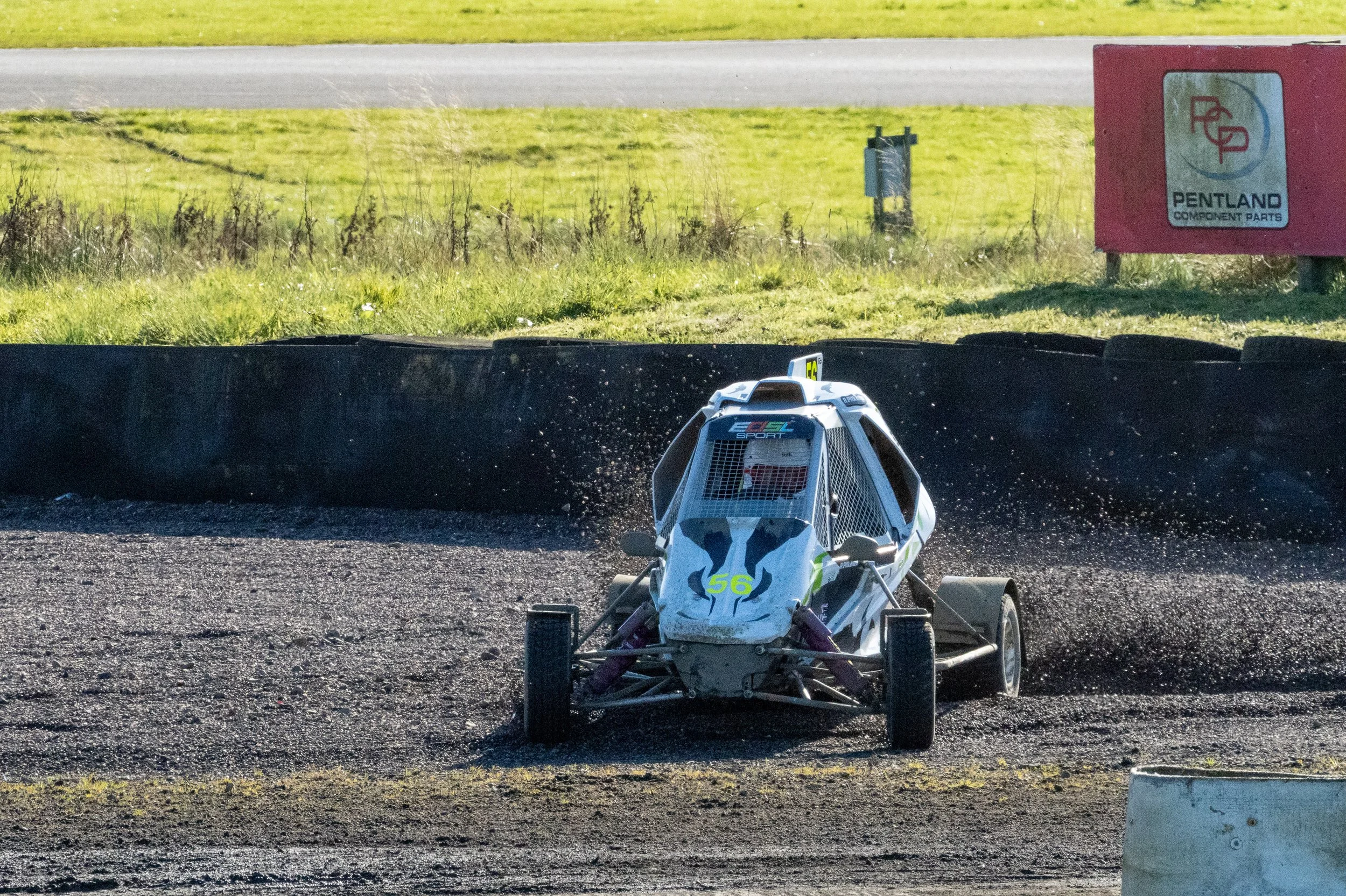 A white race car with the number 56 on it goes off track during a Rallycross event at Knockhill, Scotland.