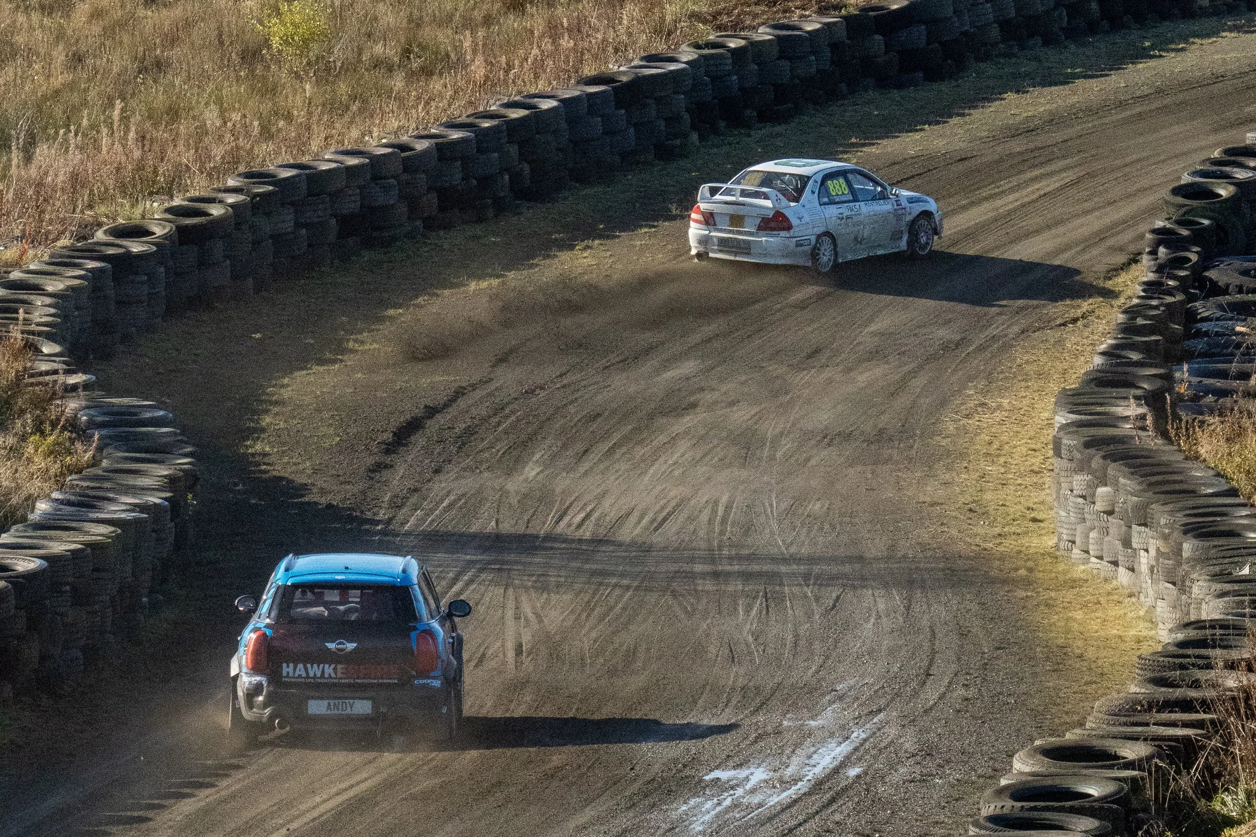 Cars racing on the dirt track section of Knockhill, Scotland during a Rallycross event.