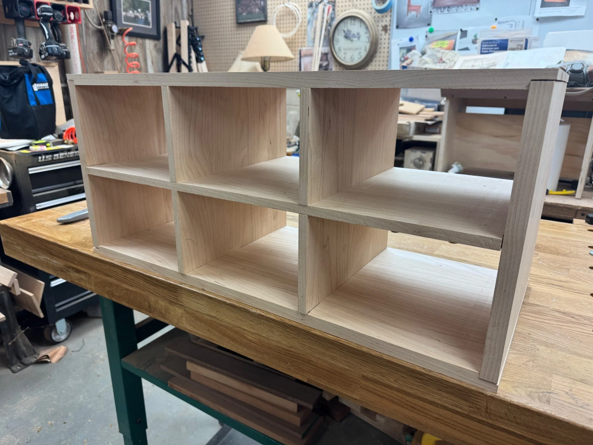 unfinished wooden shelving unit on a workbench in a workshop