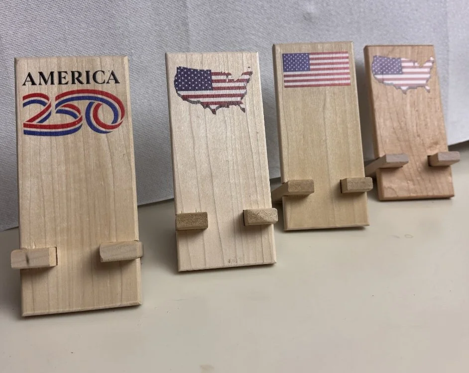 Four wooden standees with American patriotic designs and flags, arranged from left to right.