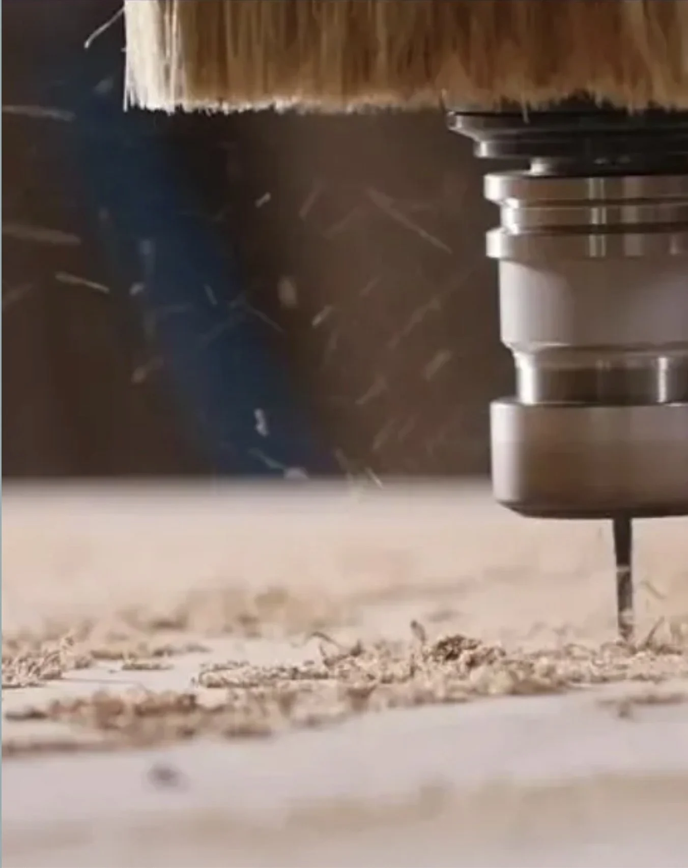 Close-up of a CNC machine cutting through metal, metal shavings scattered on the surface.