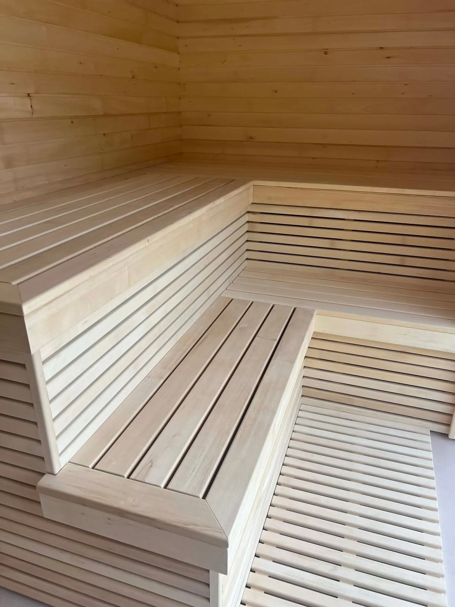 Interior of a Nordbadstu timber sauna with light corner benches