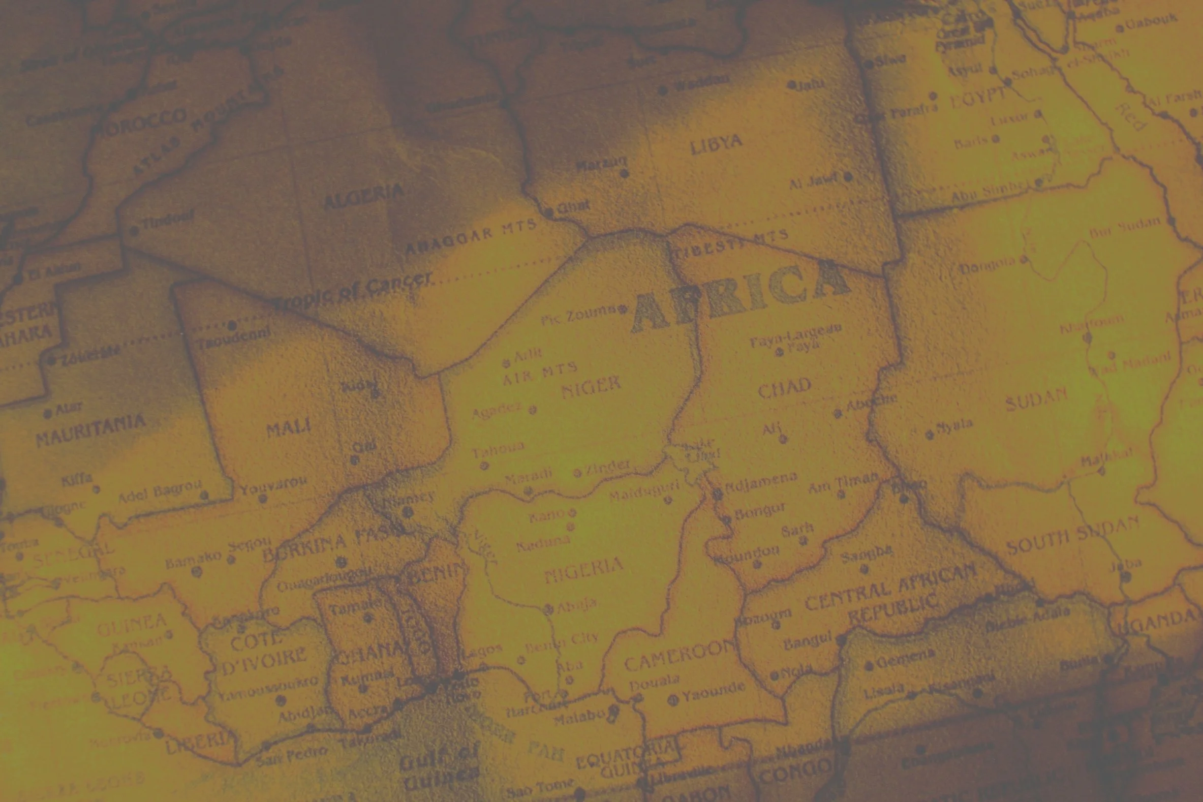 A vintage map showing the continent of Africa with countries labeled, including Libya, Algeria, and Nigeria, and geographical features like mountain ranges and cities.