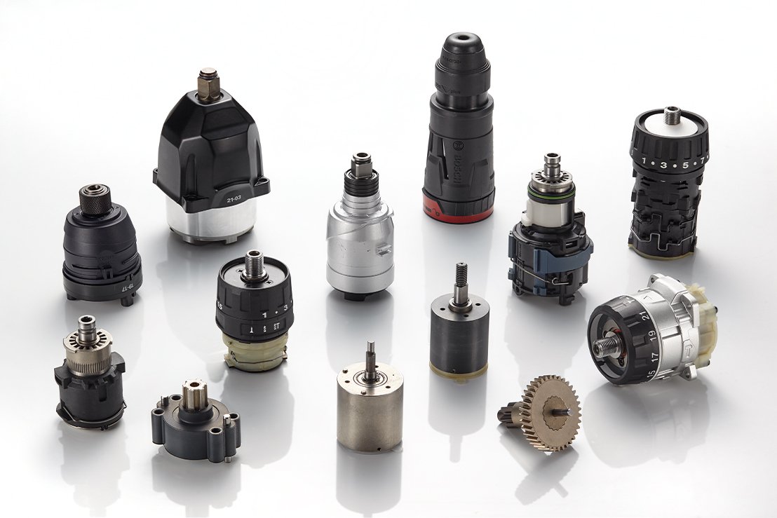 Various industrial machine tools and rotary encoders on a white surface.